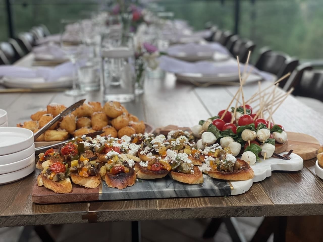 A long set table with appetizer boards ready for guests