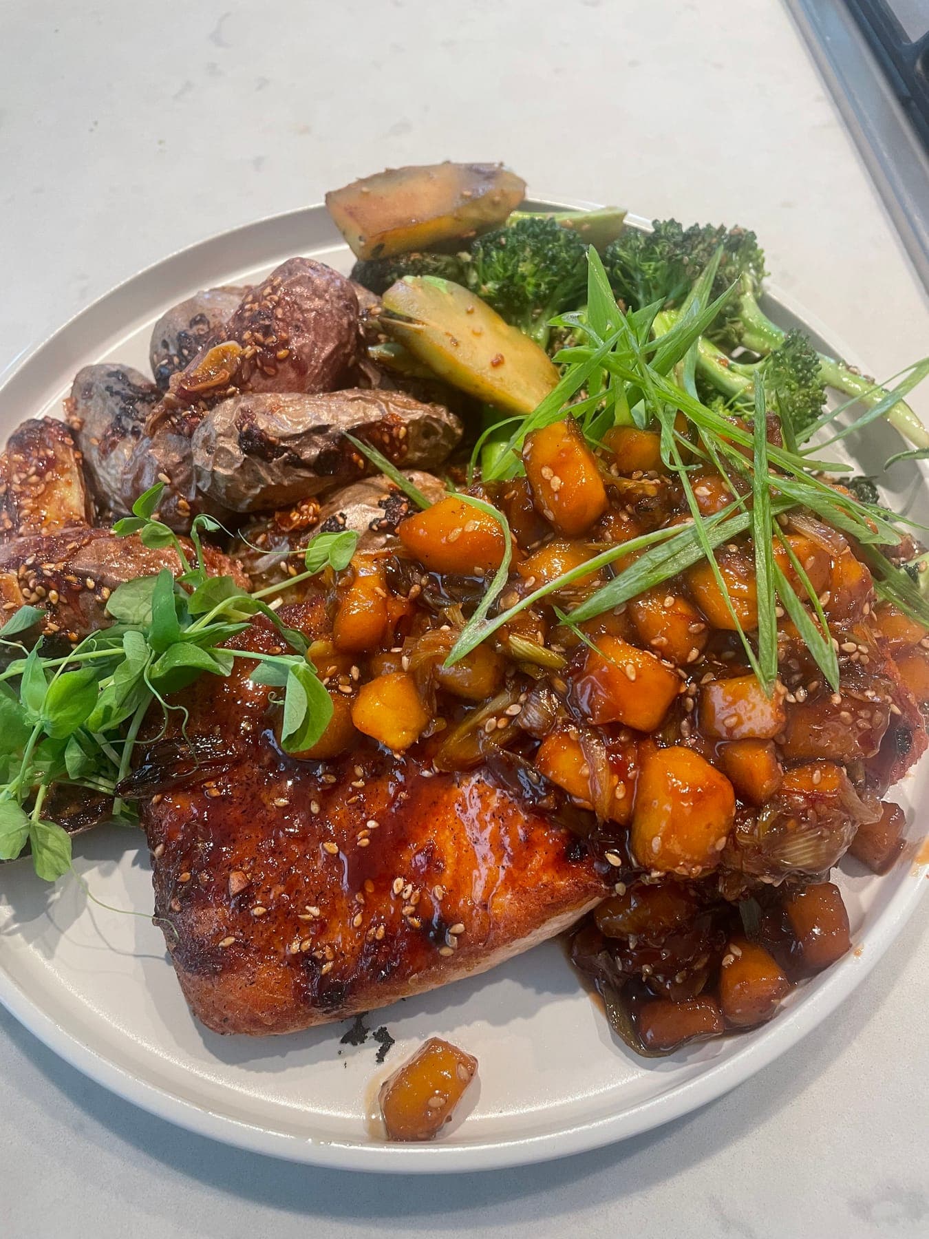 A glazed salmon plate with squash, broccoli and herbs